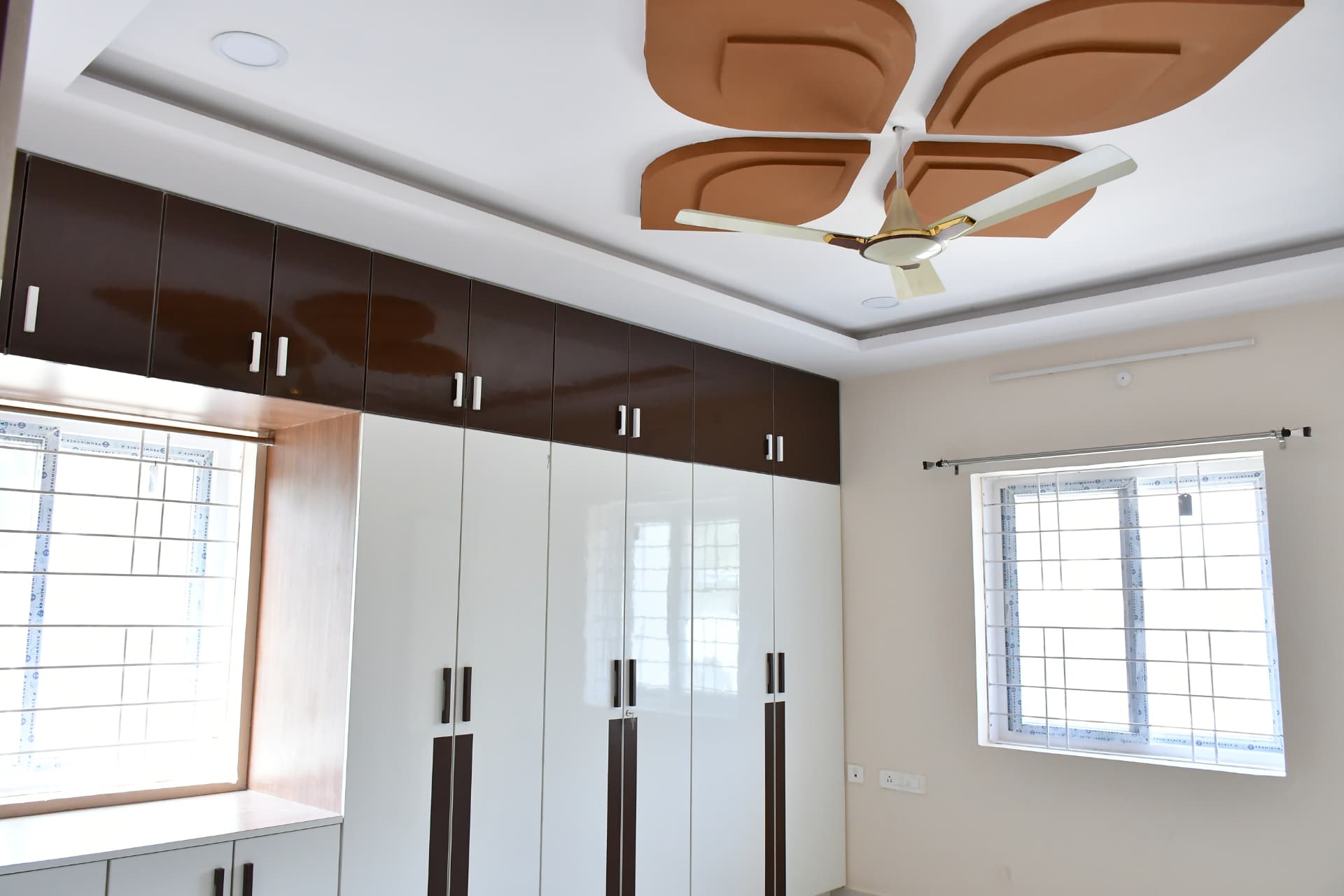 Mrs. Vasundara's Residence, Ballari — Bedroom with full-height wardrobe and a leaf-motif false ceiling