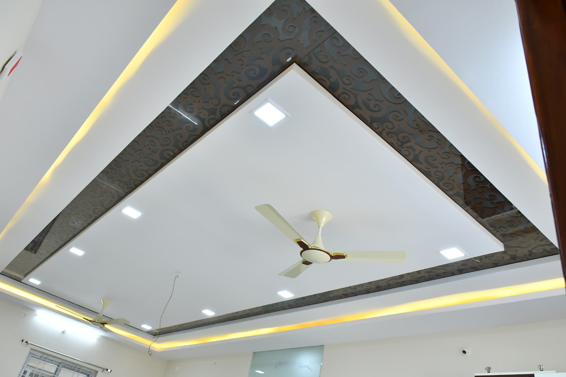 Mrs. Vasundara's Residence, Ballari — Triangular false ceiling with printed high-gloss laminate borders and warm cove lighting