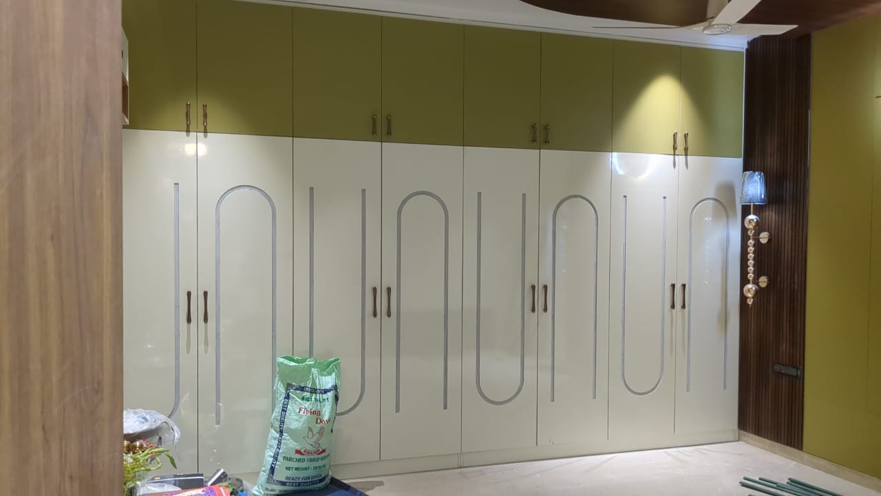 Ajay's House, Ballari — Olive and ivory bedroom wardrobe with arched groove detailing