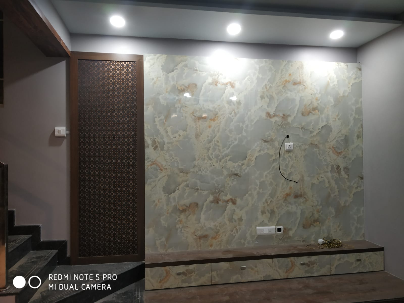 Umer's Residence, Bengaluru — Onyx-look TV wall with concealed drawers and a perforated wood screen