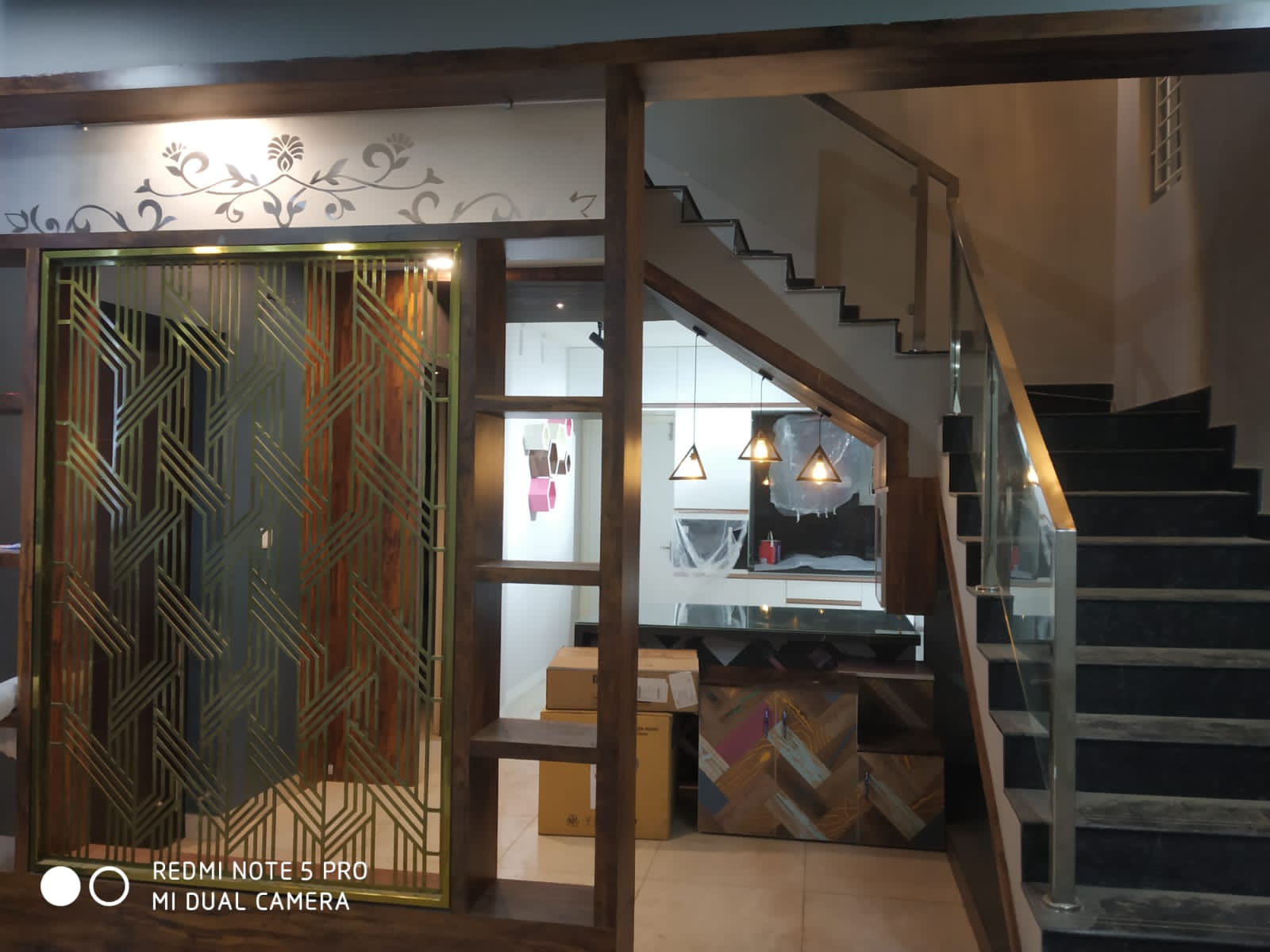 Umer's Residence, Bengaluru — Entrance screen and under-stair storage with black granite treads and glass railing