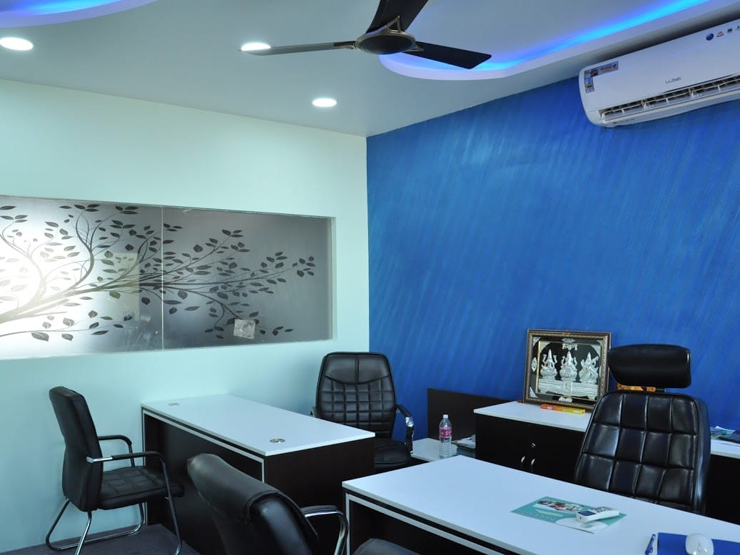 BSR Infra Office, Ballari — Staff cabin with textured blue feature wall and back-lit tree art panel