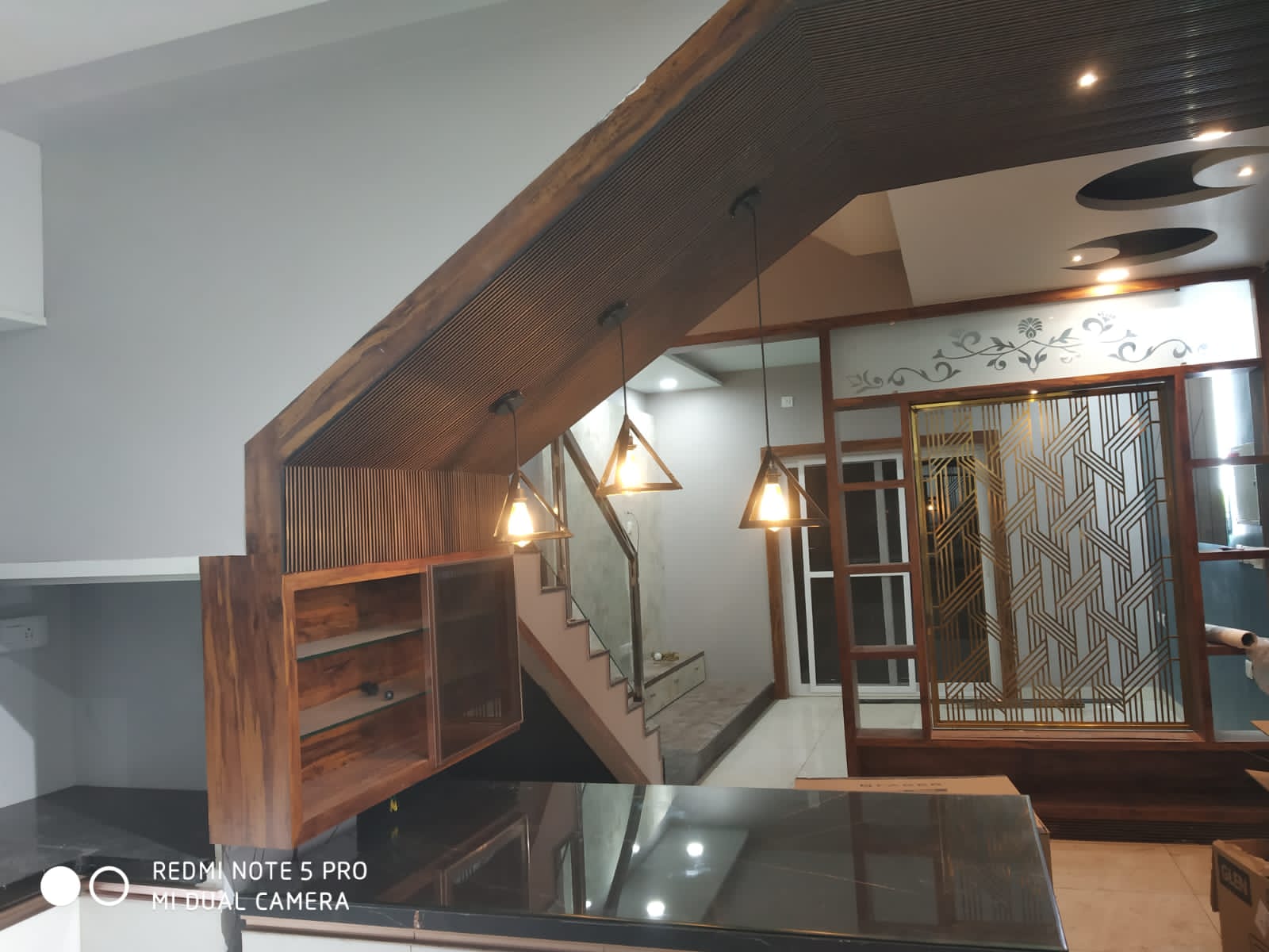 Umer's Residence, Bengaluru — Open plan view from the kitchen counter toward the glass-railed staircase